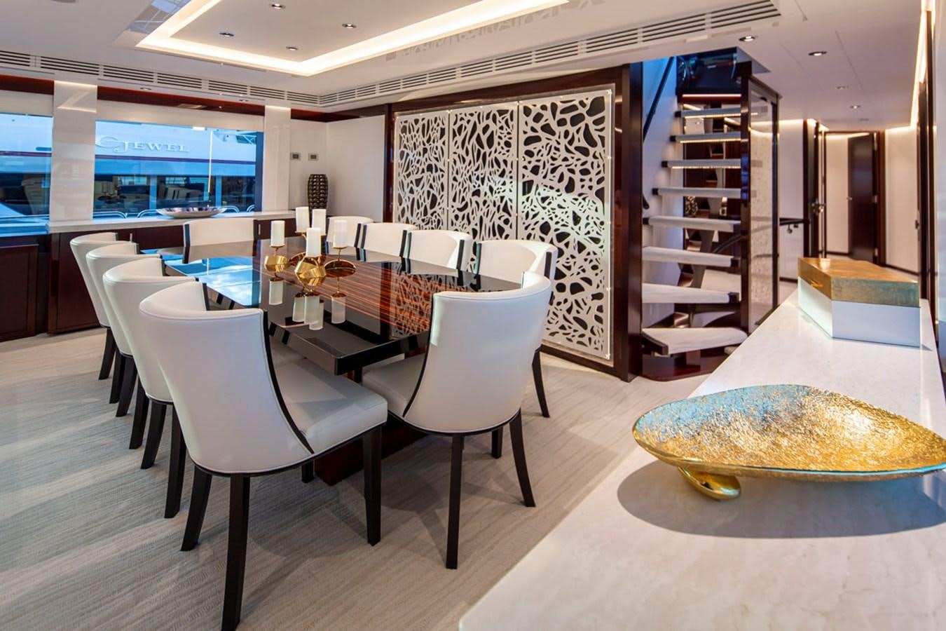 a room with a table chairs and a staircase aboard LION'S DEN Yacht for Sale