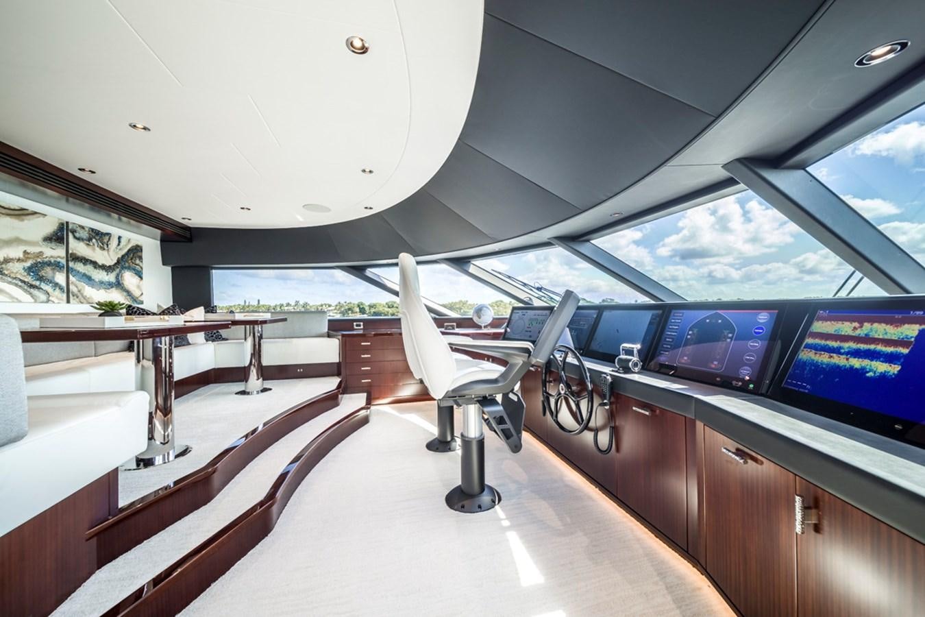 a room with a large window and a desk with chairs and computers aboard LION'S DEN Yacht for Sale