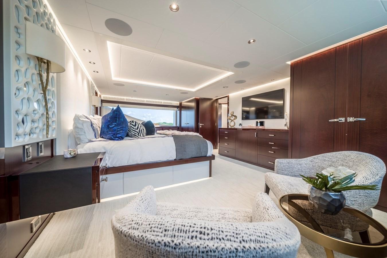 a bedroom with a bed and a table aboard LION'S DEN Yacht for Sale