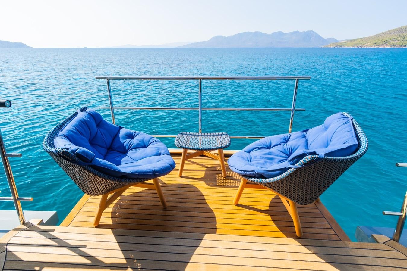 a deck with chairs on it by the water aboard LEONIDAS Yacht for Sale