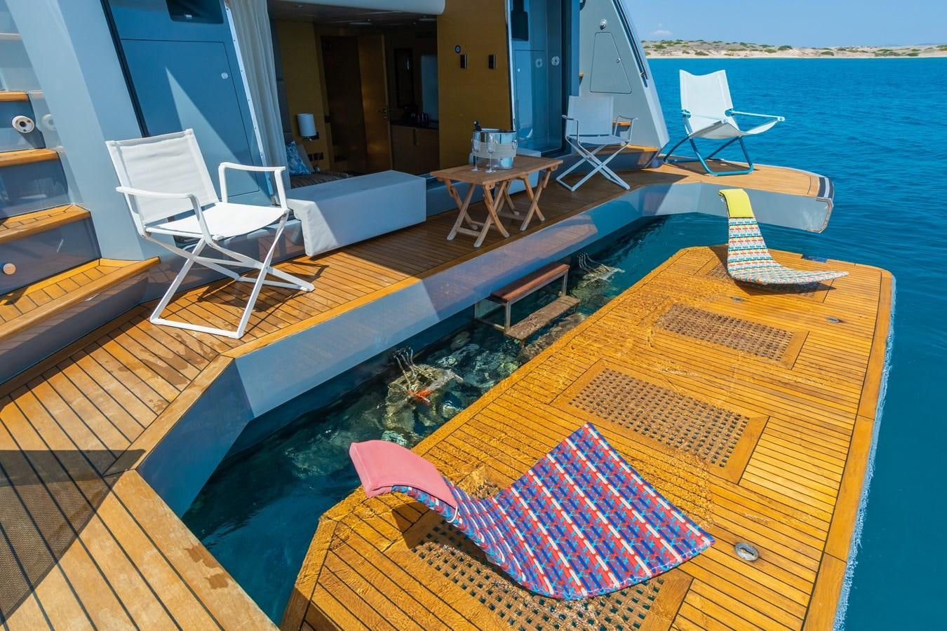 a deck with a pool and chairs aboard LEONIDAS Yacht for Sale