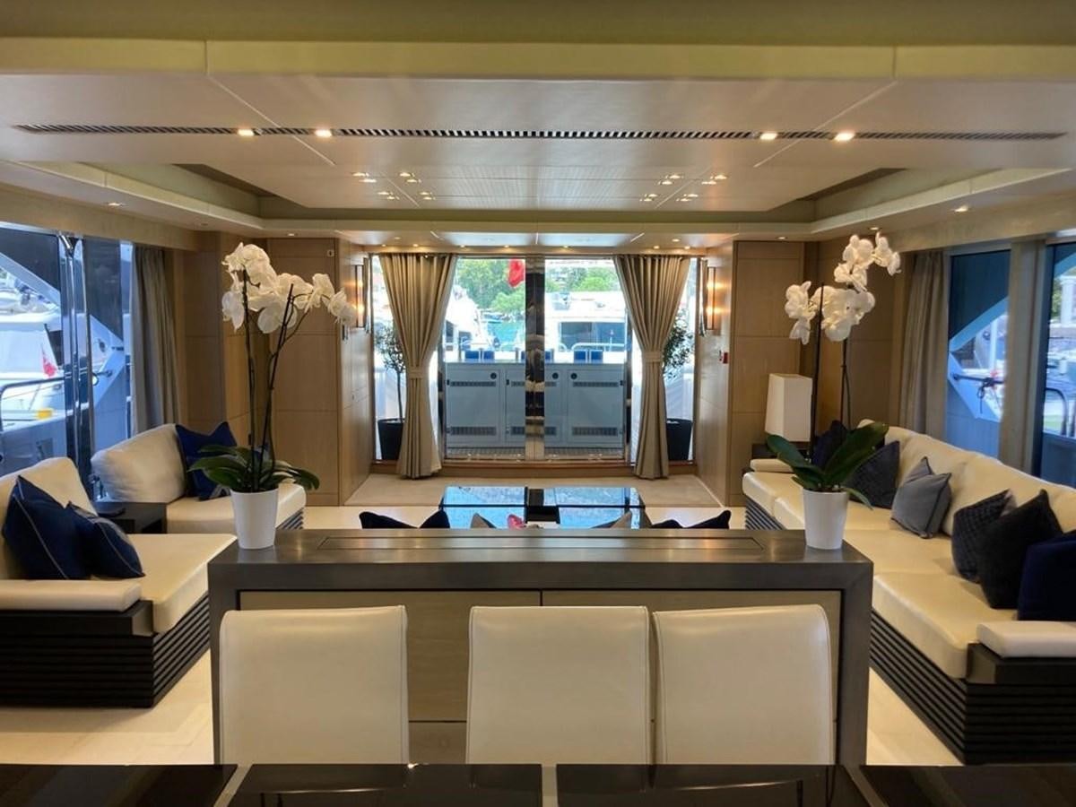 a room with a table chairs and flowers in it aboard R2 Yacht for Sale