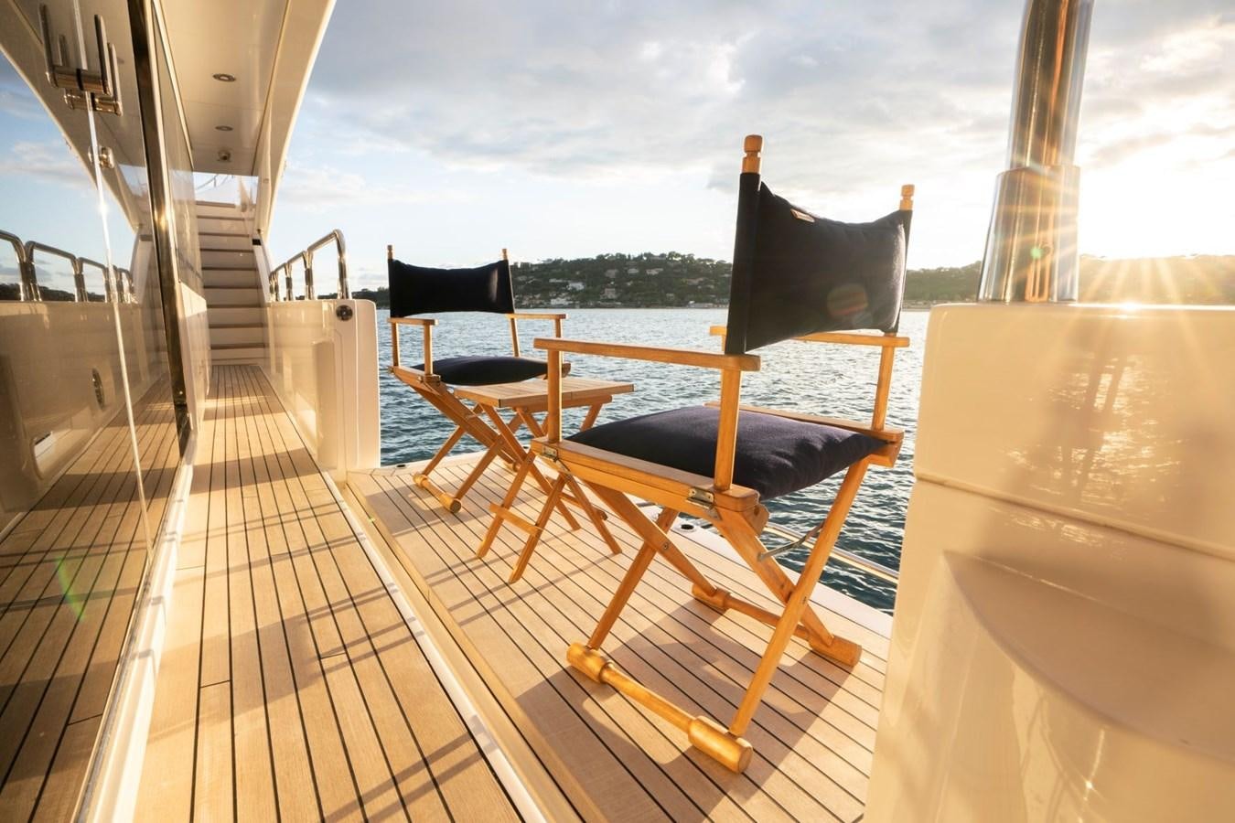 a deck with chairs and a table aboard R2 Yacht for Sale