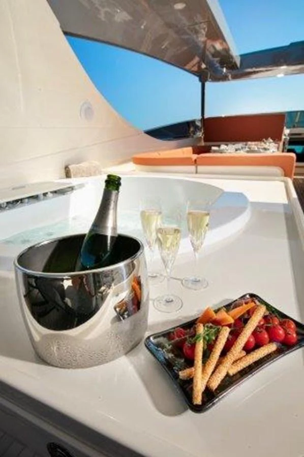 a plate of food and a glass of wine on a table aboard Y42 Yacht for Sale