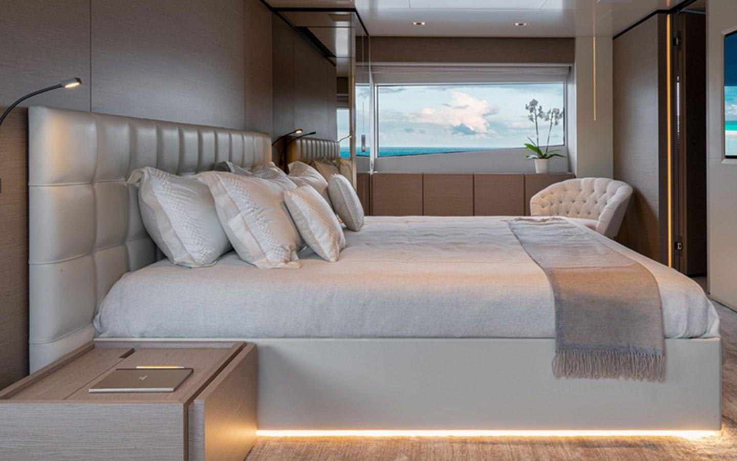 a bed with a table and a window aboard ADELIA Yacht for Sale