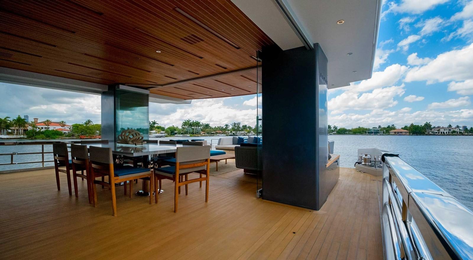 a wood deck with a large window overlooking a body of water aboard CYRA Yacht for Sale