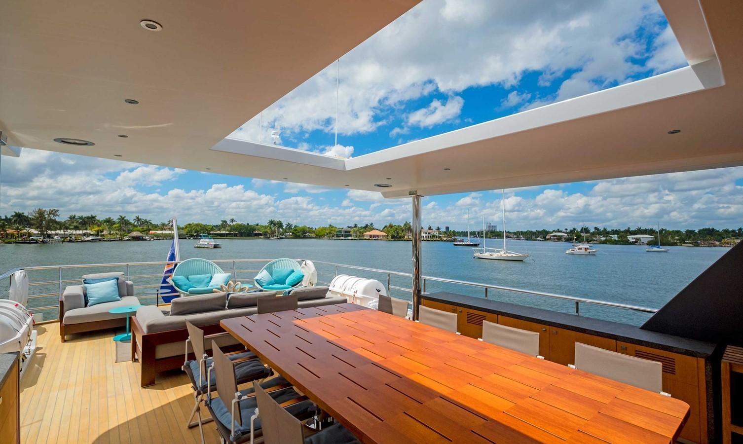 a room with a table chairs and a view of the water aboard CYRA Yacht for Sale