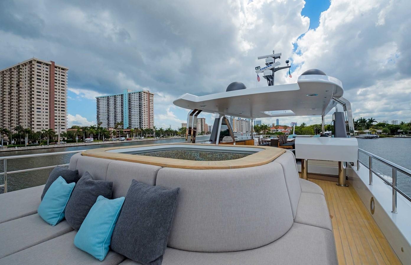 a large white lounge chair on a deck overlooking a city aboard CYRA Yacht for Sale