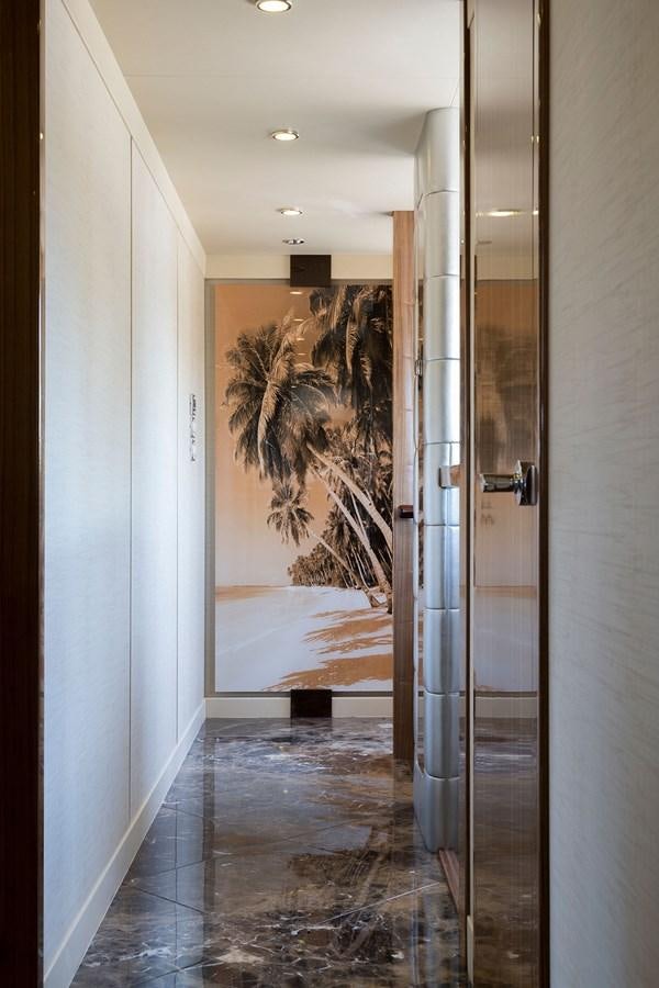 a large glass door with a glass wall and a palm tree in the background aboard OUR TRADE Yacht for Sale