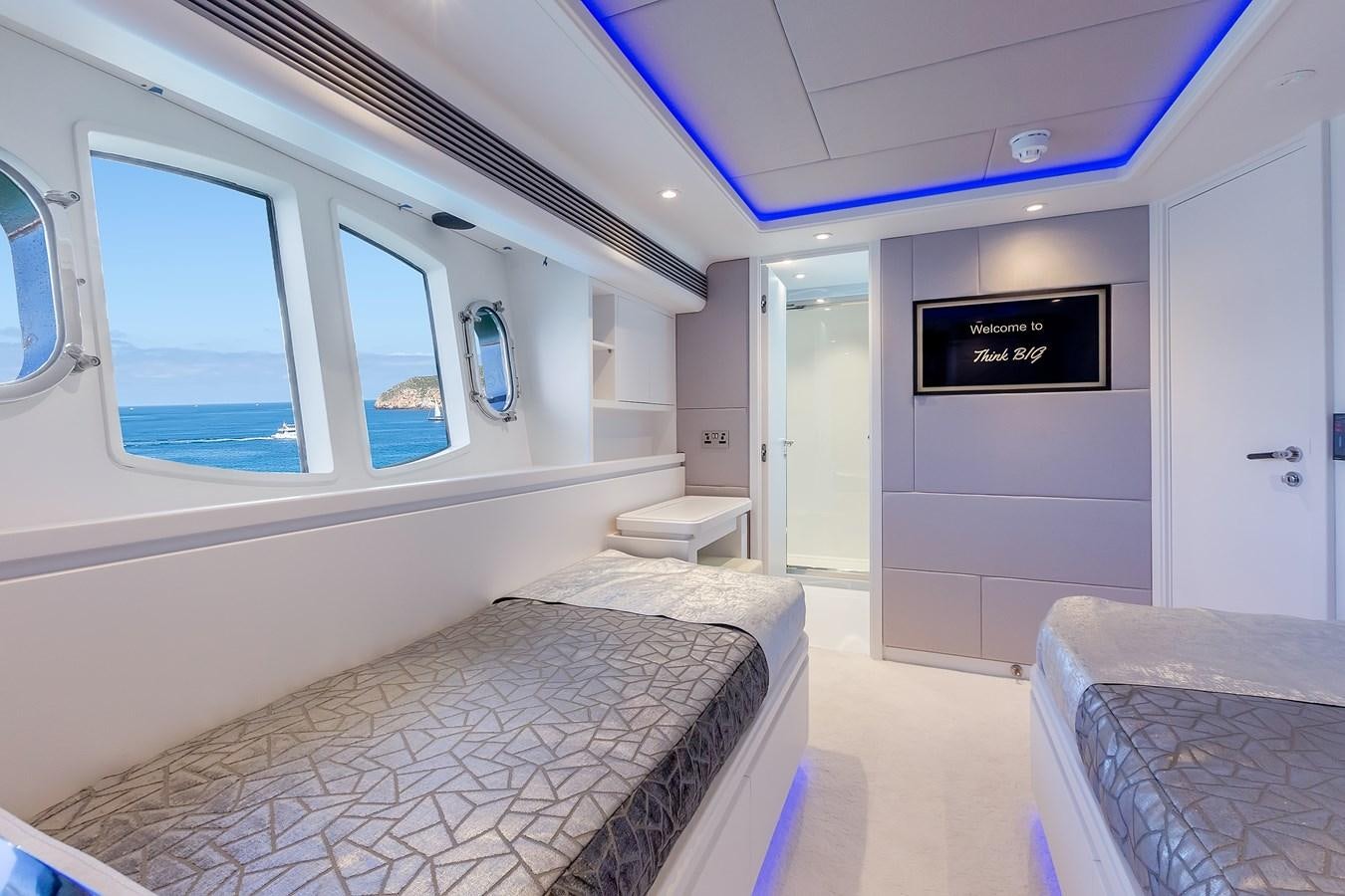 a room with a bed and a window aboard THINK BIG Yacht for Sale