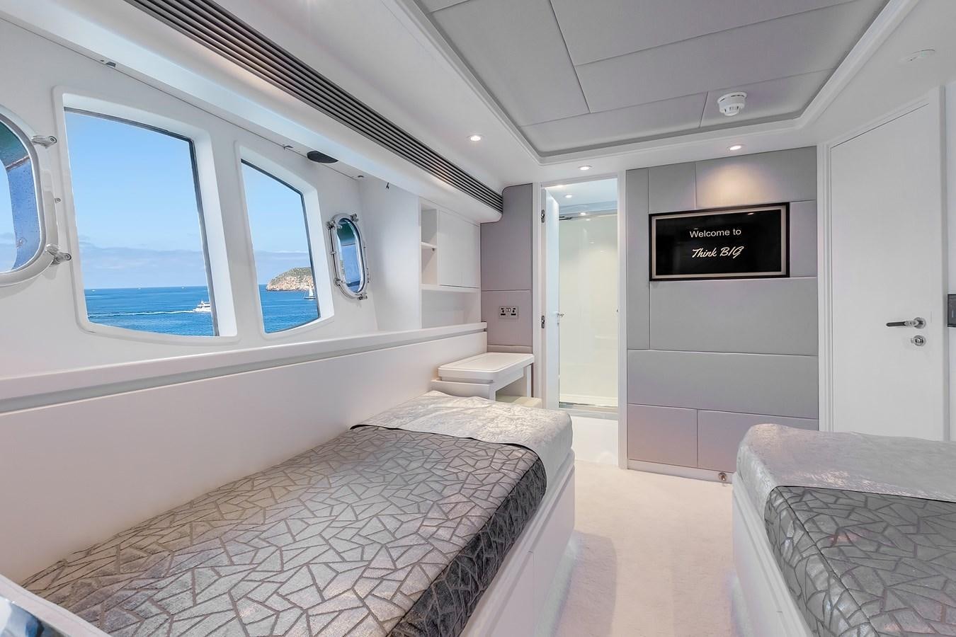 a room with a bed and a chair aboard THINK BIG Yacht for Sale