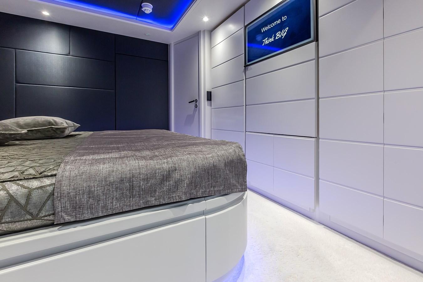 a room with a bed and a television aboard THINK BIG Yacht for Sale