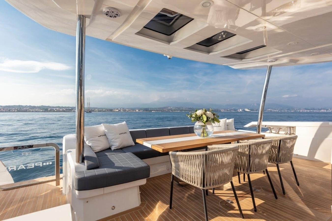 a table and chairs on a deck aboard PEARL Yacht for Sale
