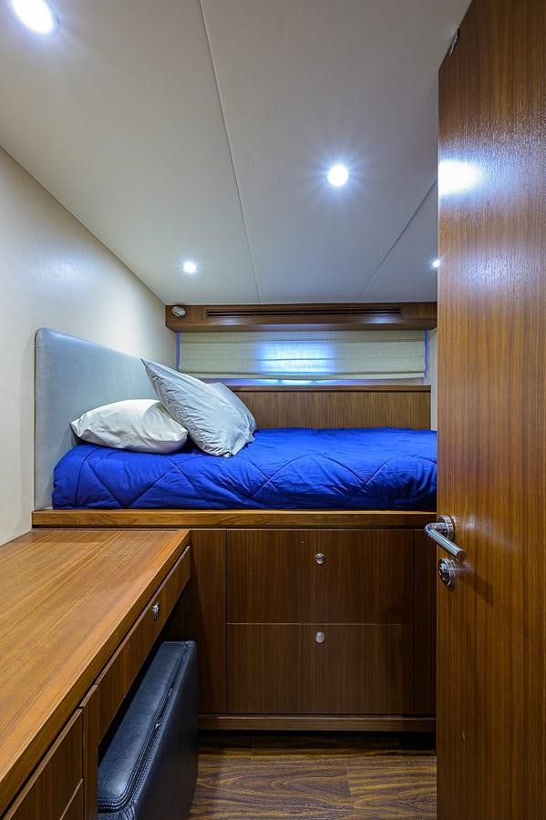 a bed with a blue comforter aboard ONE SHOT Yacht for Sale