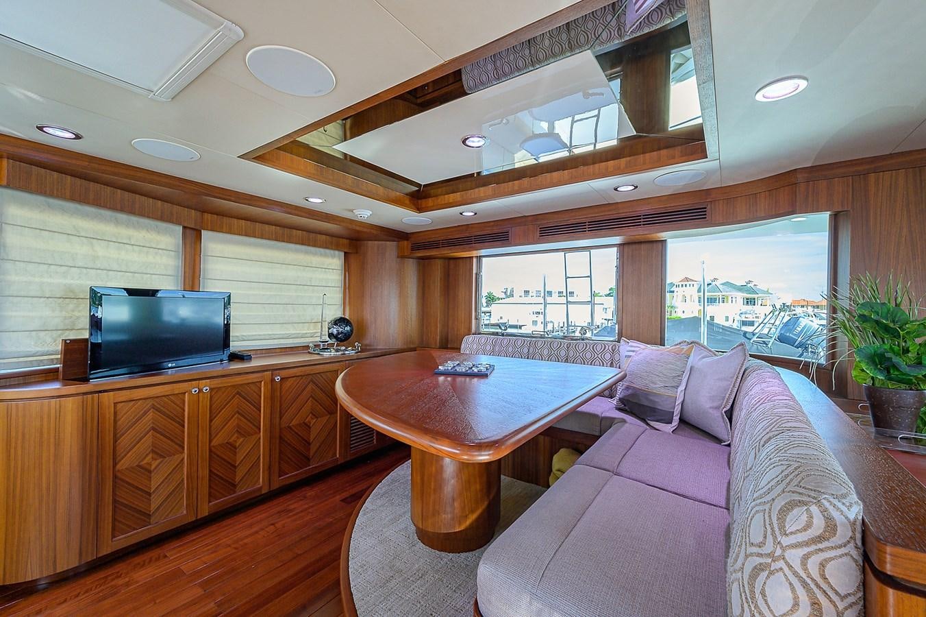 a living room with a table and couches aboard ONE SHOT Yacht for Sale