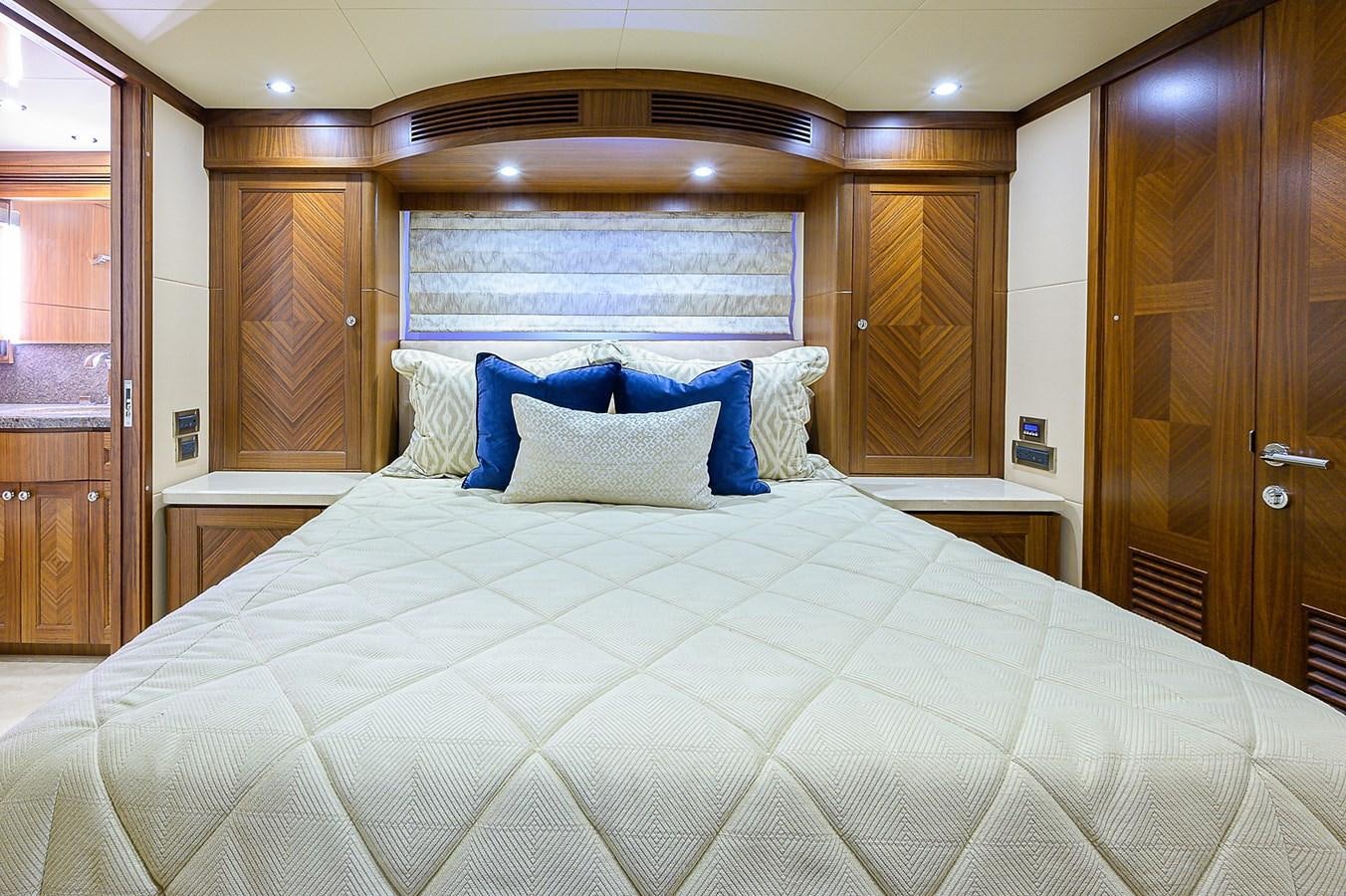 a bed with a blue and white comforter aboard ONE SHOT Yacht for Sale