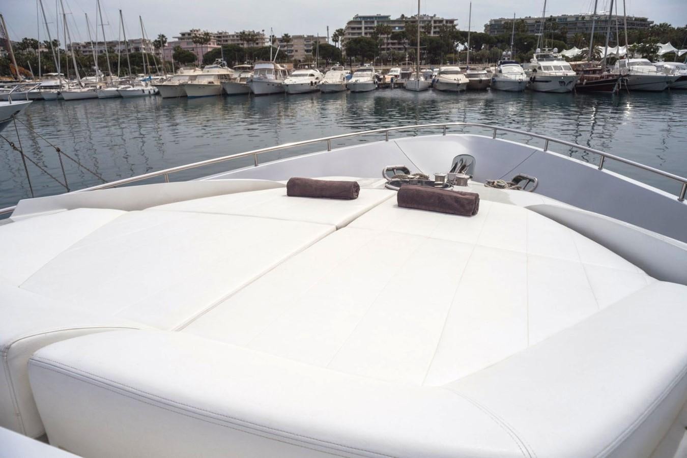 a white boat in a harbor with Ice hockey rink in the background aboard A&O Yacht for Sale