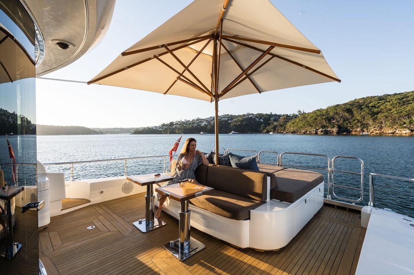 a person sitting on a couch under an umbrella on a deck aboard PALOMA Yacht for Sale