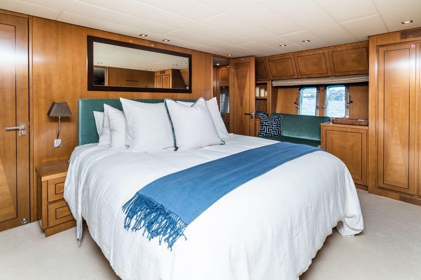 a bed with blue sheets aboard PALOMA Yacht for Sale