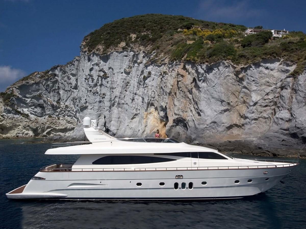 a white yacht in front of a large mountain aboard HABANO Yacht for Sale