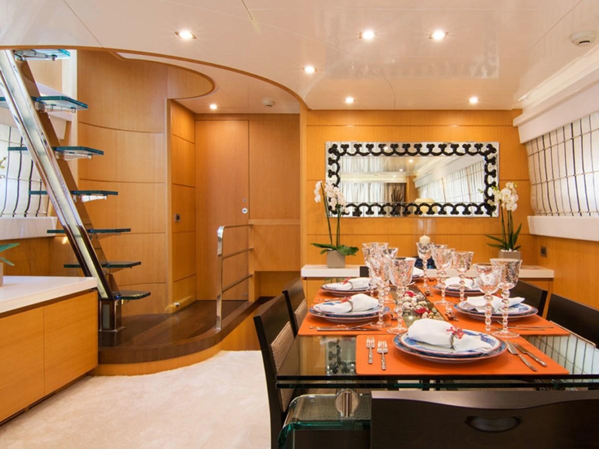 a dining room with a set of stairs and a table with plates and glasses on it aboard HABANO Yacht for Sale