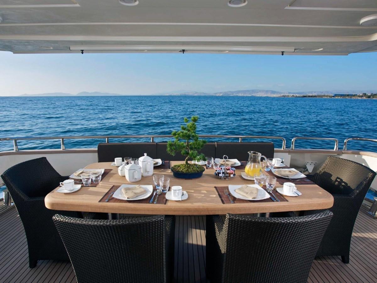 a table set with chairs and a plant on the table aboard HABANO Yacht for Sale