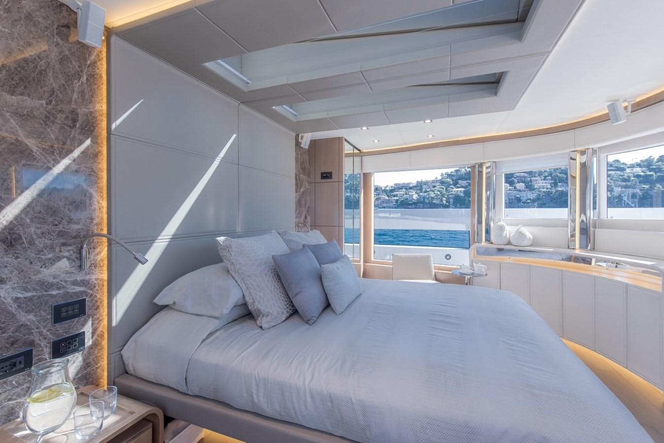 a bed with a large window aboard 7 SECONDS Yacht for Sale