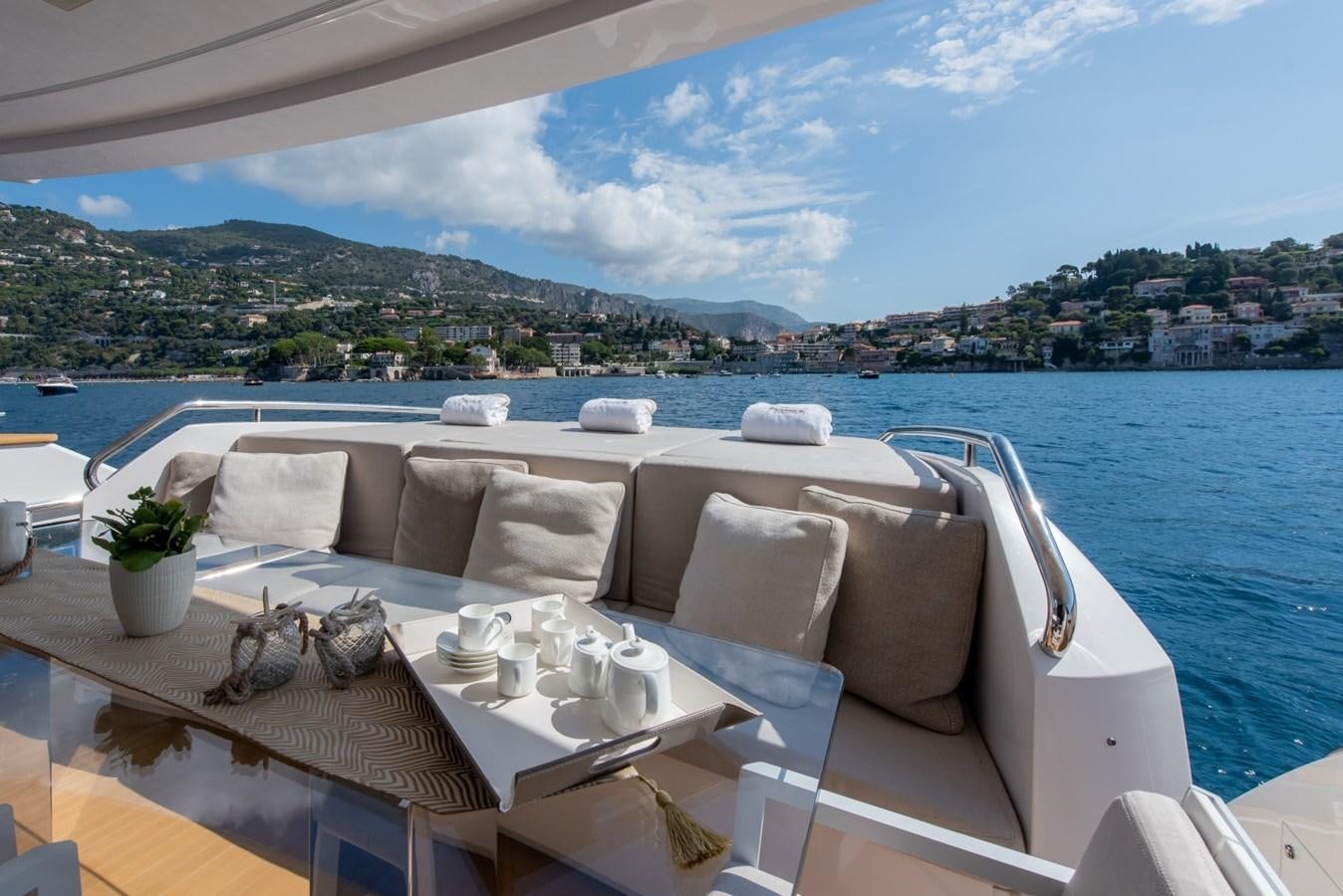a table with chairs on it next to a body of water aboard 7 SECONDS Yacht for Sale