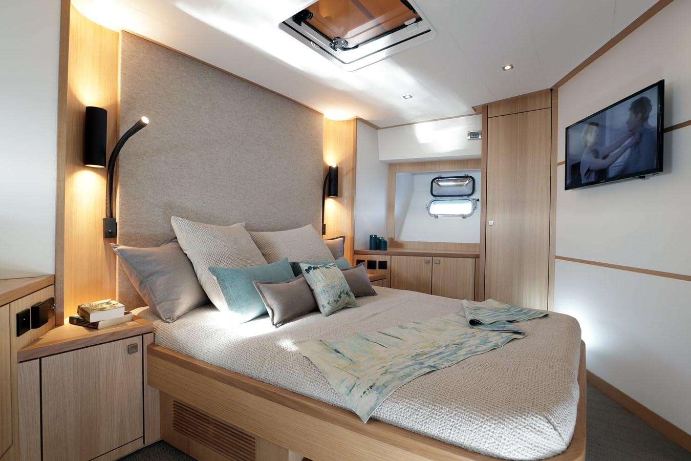 a bed with a television on the wall aboard ARMONEE Yacht for Sale
