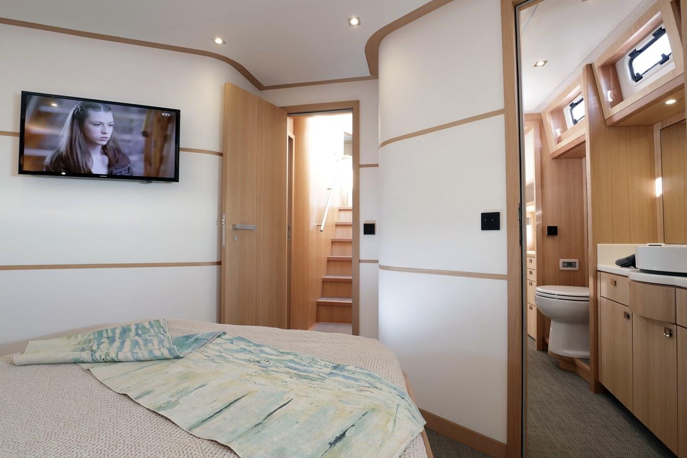 a bedroom with a bed and a television on the wall aboard ARMONEE Yacht for Sale