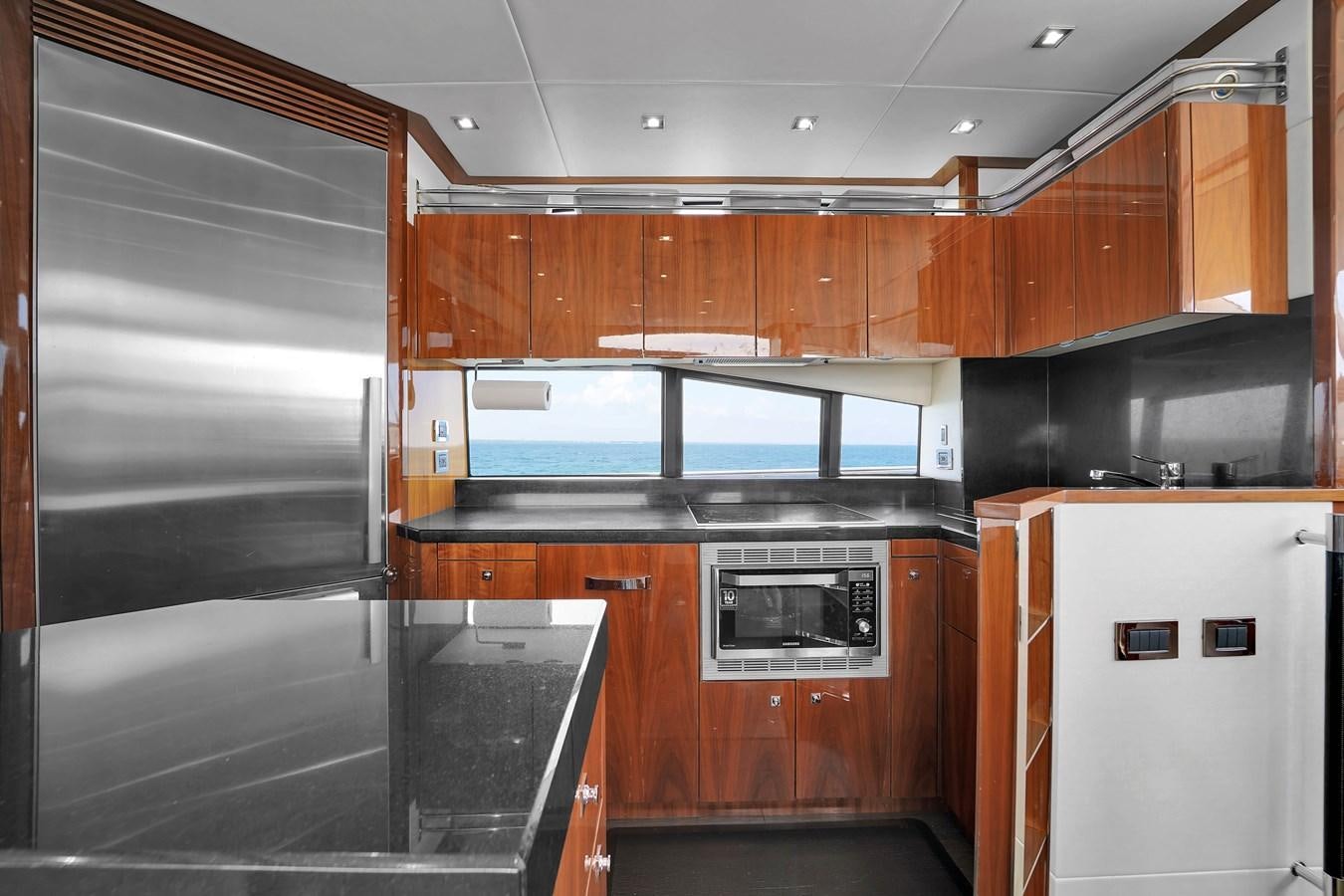 a kitchen with wooden cabinets aboard SUNSEEKER 73 2013 Yacht for Sale