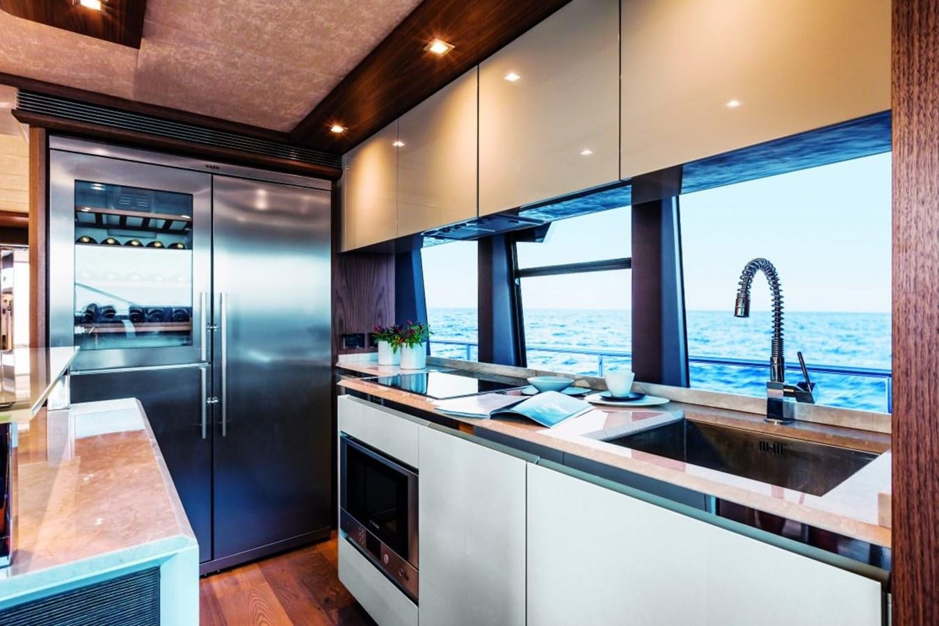 a kitchen with black appliances aboard 72 FLY Yacht for Sale