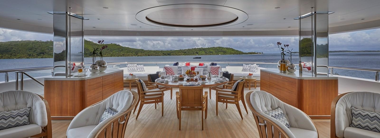 a dining table with chairs and a view of the water aboard IJE Yacht for Sale