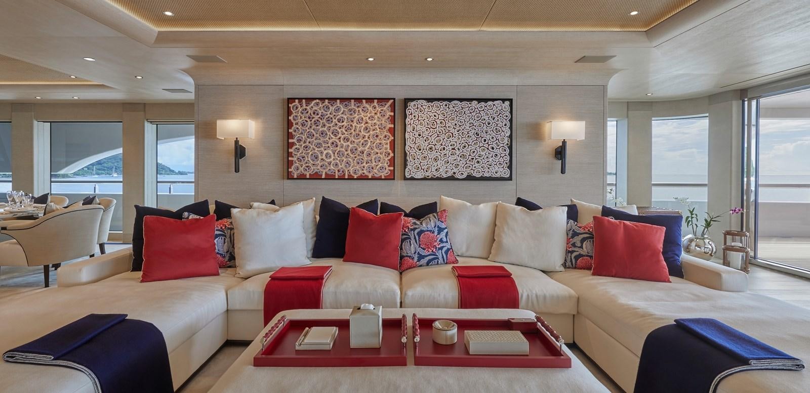 a large living room with a white couch and red pillows aboard IJE Yacht for Sale