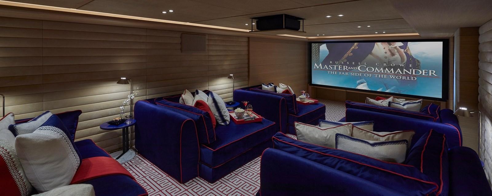 a room with a screen and a couch aboard IJE Yacht for Sale