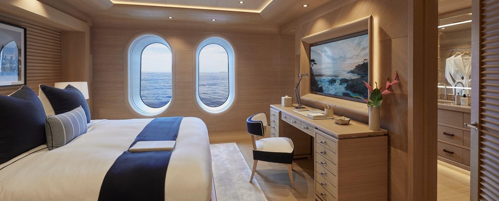 a room with a bed and a desk and a tv aboard IJE Yacht for Sale