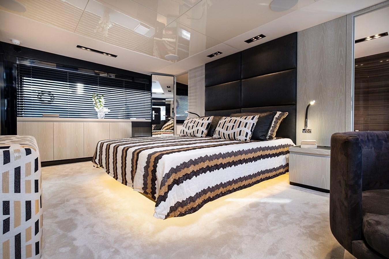 a modern looking bedroom with a large bed and a black cabinet aboard ALIX Yacht for Sale