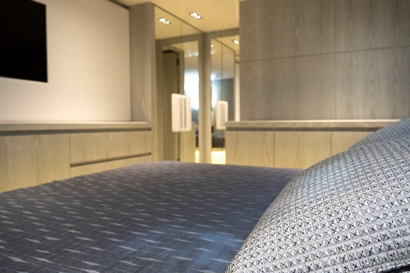 a bed with a blue comforter aboard ALIX Yacht for Sale