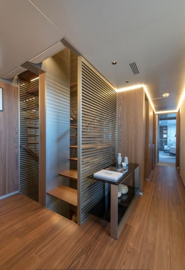 a room with a wood staircase and a desk with a computer on it aboard MYKO Yacht for Sale