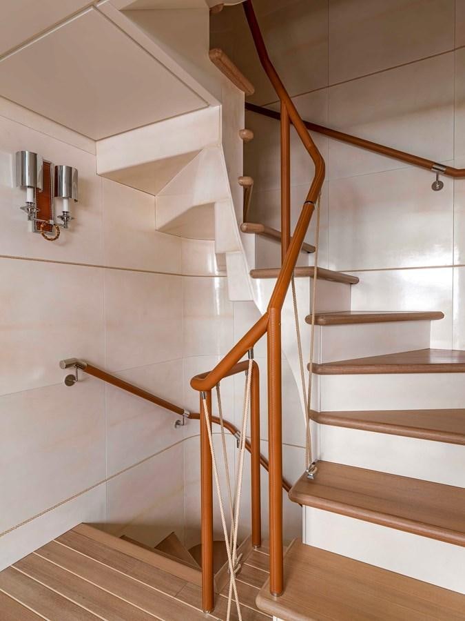 a wooden staircase with a metal railing aboard PAIZA ONE Yacht for Sale