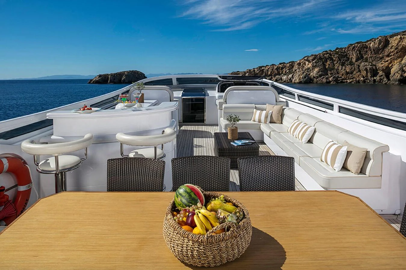 a table with chairs and a basket of fruit on it aboard MAIORA 35 DP Yacht for Sale