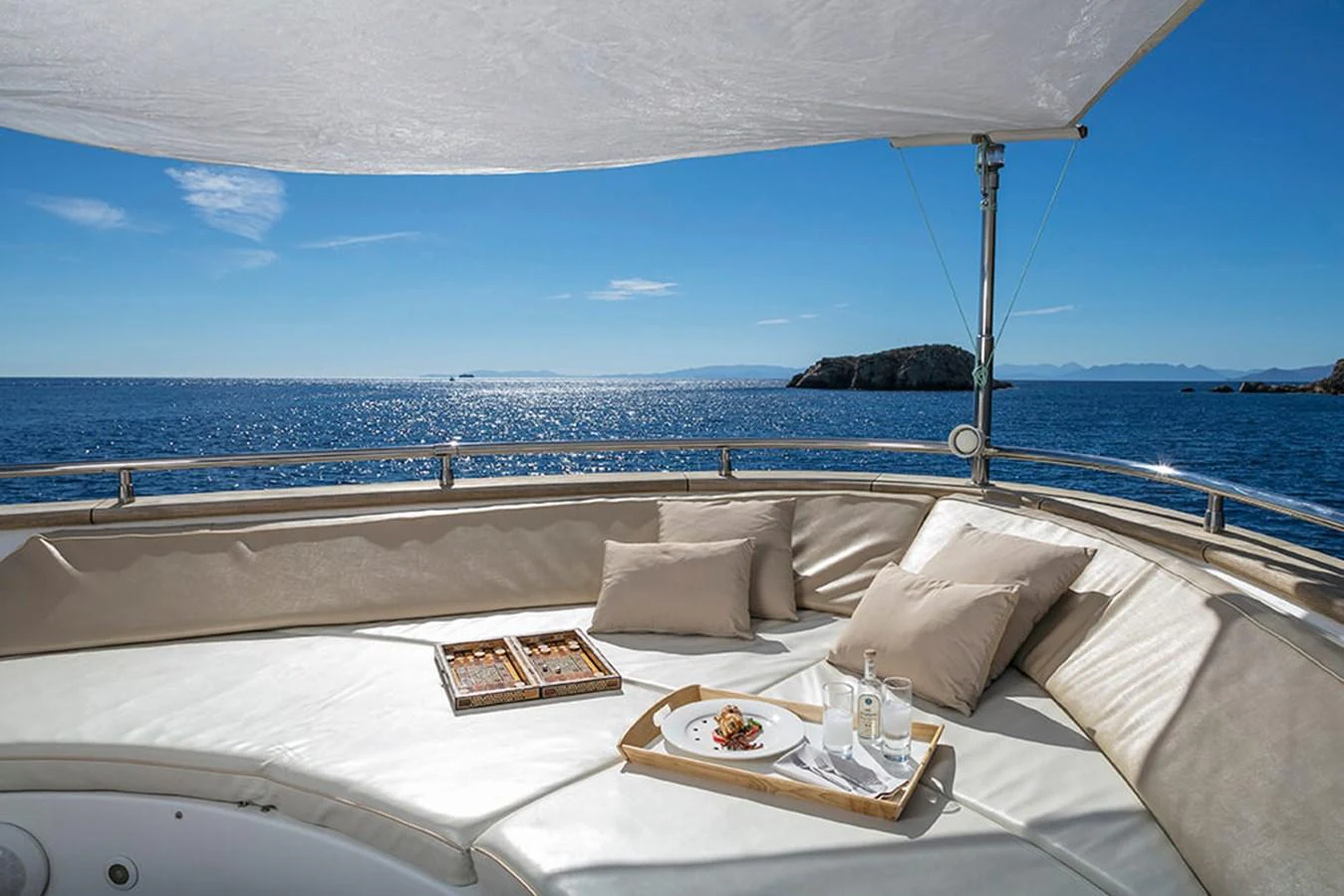 a bed with a white bed spread and a white table with a white cloth and a blue sky aboard MAIORA 35 DP Yacht for Sale