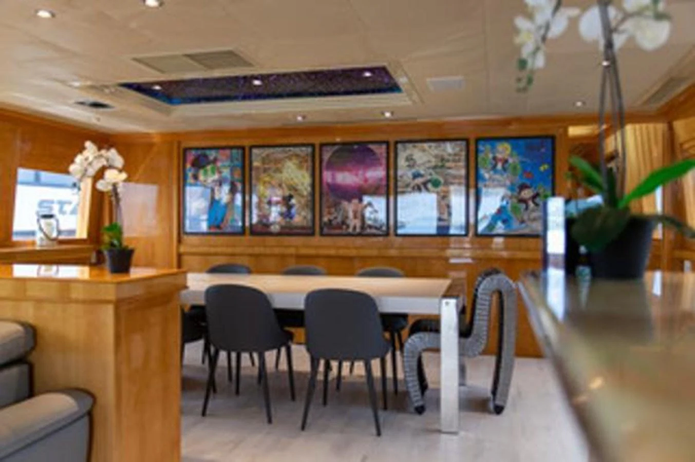 a room with a table chairs and plants aboard 2000 116 BAGLIETTO Yacht for Sale