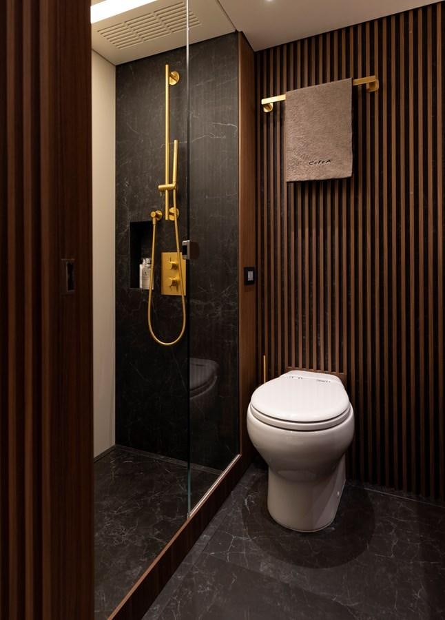 a bathroom with a toilet and a shower unit aboard CEFEA Yacht for Charter