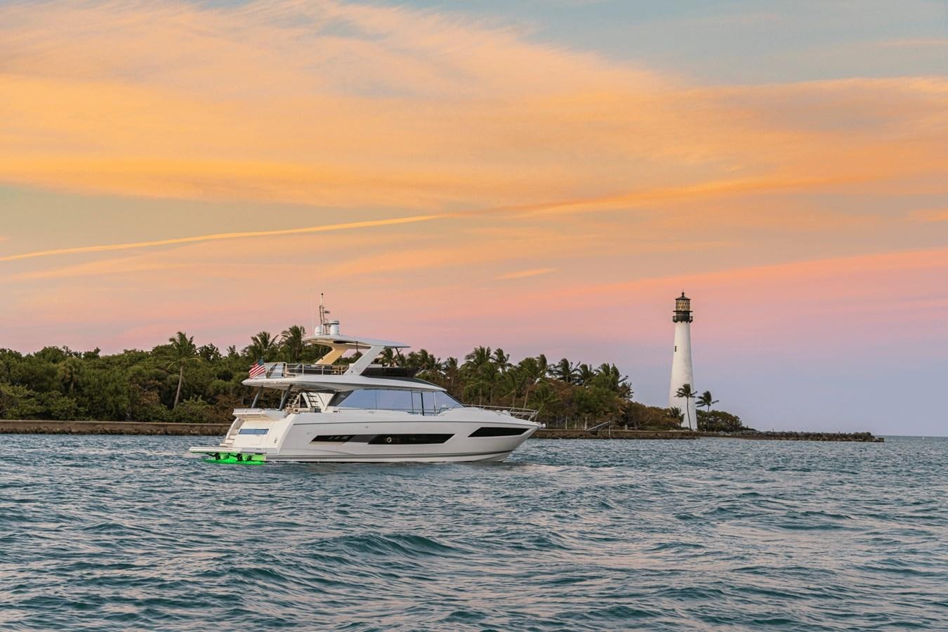a boat in the water by a lighthouse aboard 2021 PRESTIGE YACHTS 690 FLYBRIDGE Yacht for Sale