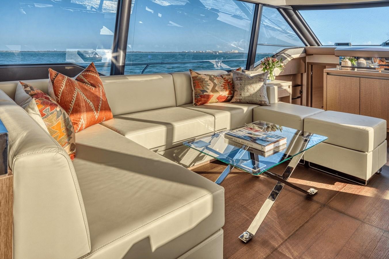a living room with a couch and a table aboard 2021 PRESTIGE YACHTS 690 FLYBRIDGE Yacht for Sale