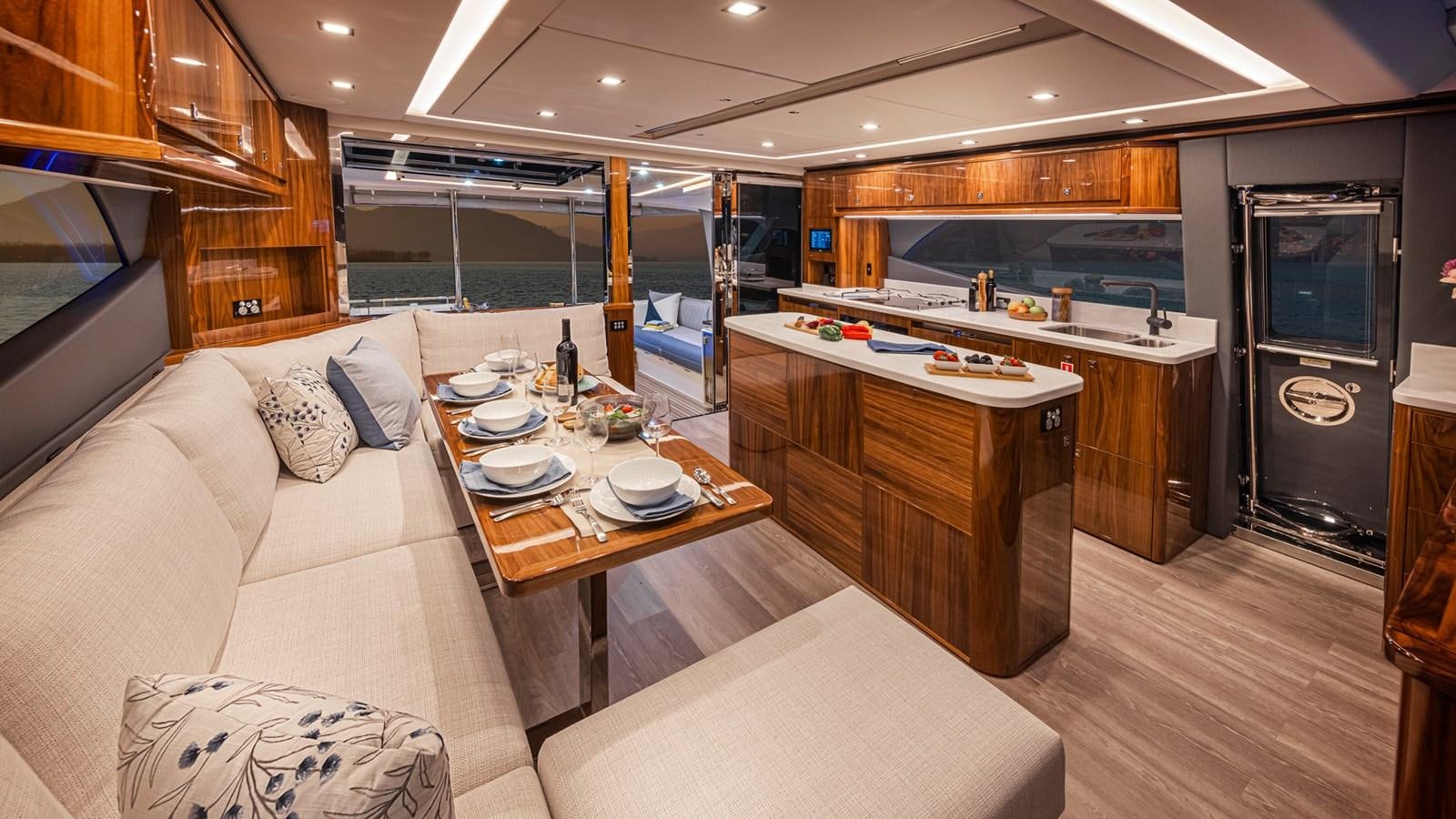 a living room with a kitchen and a dining table aboard 645 SUV Yacht for Sale