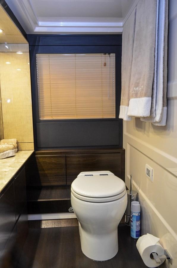 a bathroom with a toilet and a window aboard CERULEAN Yacht for Sale