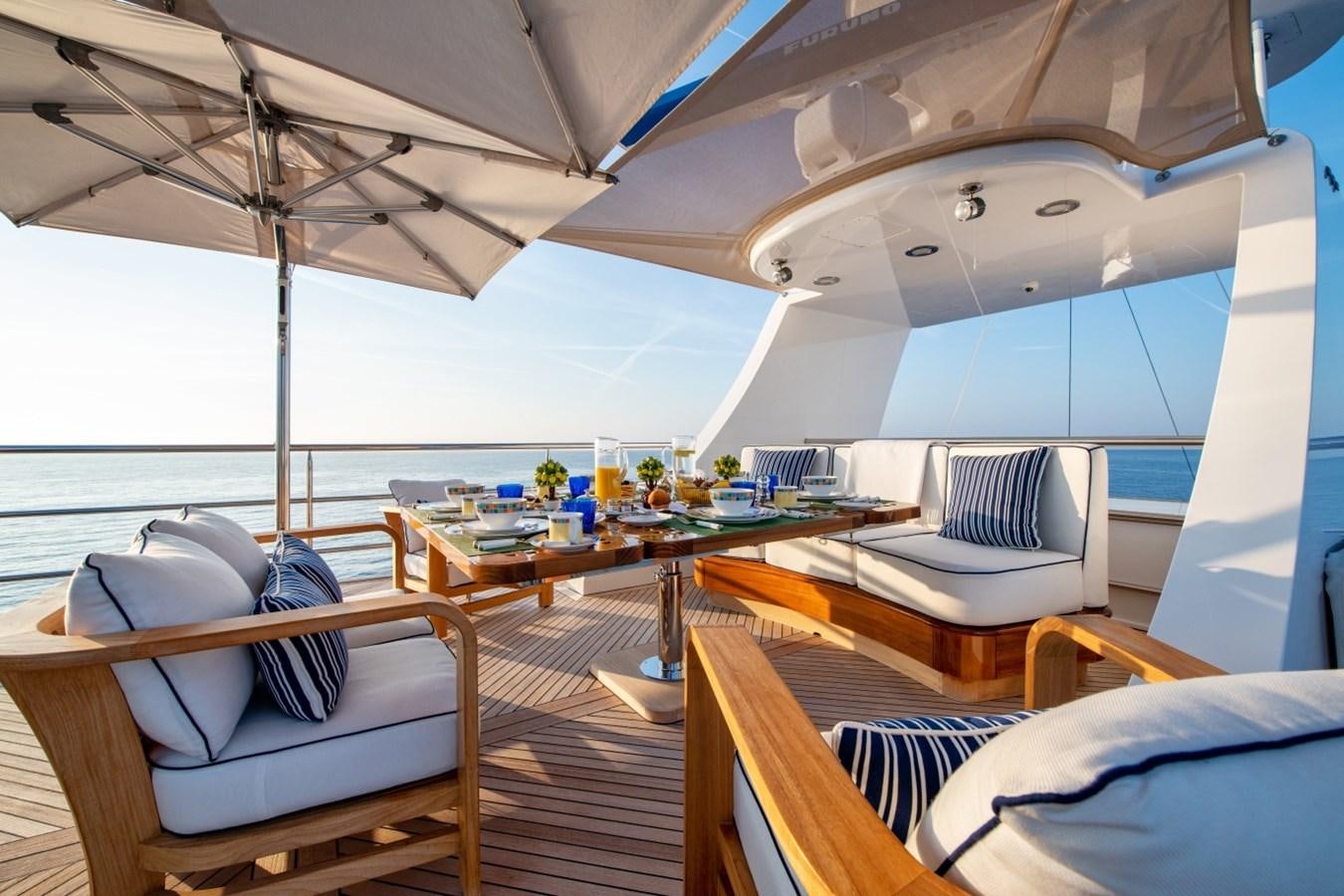 a room with a bed and a table with chairs aboard WHITE STAR Yacht for Sale