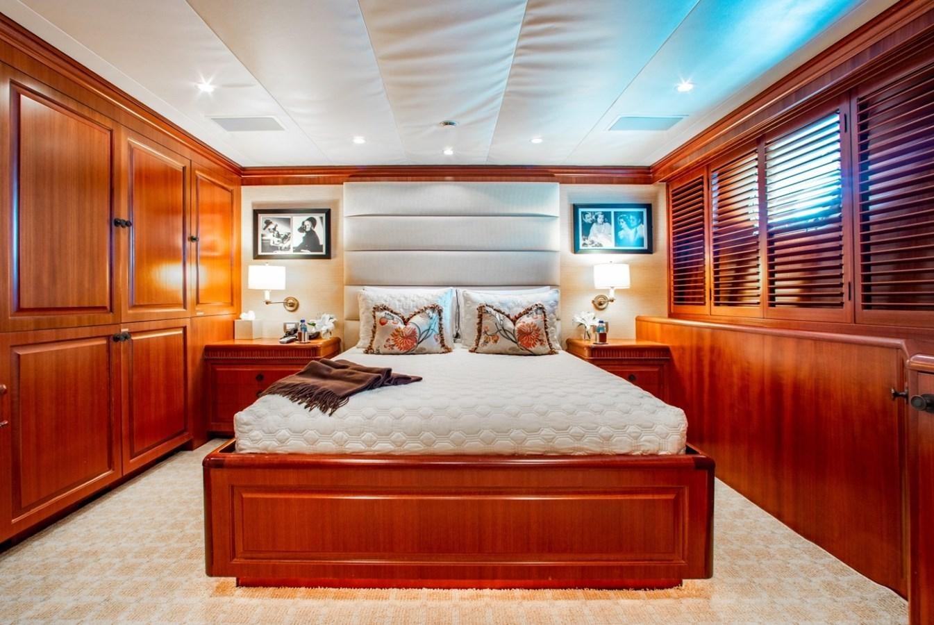 a bedroom with a bed and a wood cabinet aboard PACKAGE DEAL Yacht for Sale
